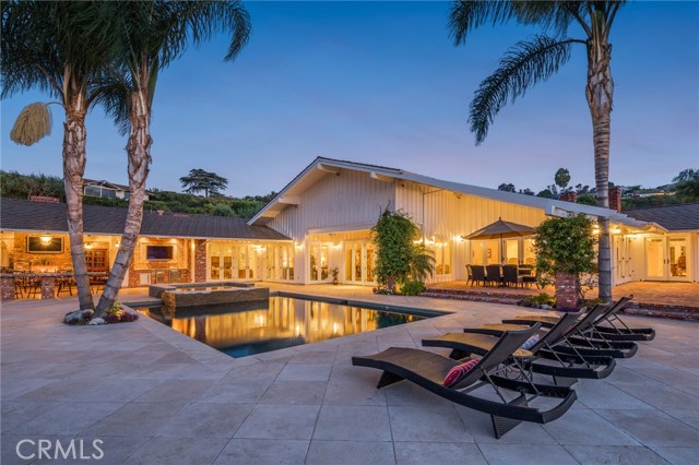 35 Saddleback Road Rolling Hills, California Resort Behind the Gates!! This exquisite Rolling Hills estate is situated on 5 acres with panoramic city views! A sprawling 8250sf of living space, 5 bedrooms and 8 bathrooms, this luxury home feels like a resort and has all of the amenities. Enjoy sunny days by the pool, grill on one of the two outdoor BBQs or relax in the private sauna. Additional activities include 2 outdoor fire pits, pizza oven, keg tap, tennis court, putting green, and an impeccably maintained, dual-waterfall, 2,200gal koi pond. Home interior includes a grand entry, exercise room, two offices, sub-zero appliances, main kitchen, secondary stainless steel chef’s kitchen, media room with kitchenette, v14 TVs, fully-integrated Crestron automation system, iPad controls, on-site generator, 7 air-conditioners with HEPA filters and UV sterilization, security cameras, emergency vault with two safes, and a beautiful brick-ceiling wine cellar. The main wing is complete with two expansive walk-in closets, an extra room for office or gym, and private laundry facilities. Attached to the main 4 car garage is a single-car garage with built-in stainless steel workshop.
Want more? This property boasts a 100-tree citrus orchard and approximately one acre of primed land complete with irrigation. A perfect canvas for orchard expansion or turn-out for horses. This unique property is the epitome of luxury living!