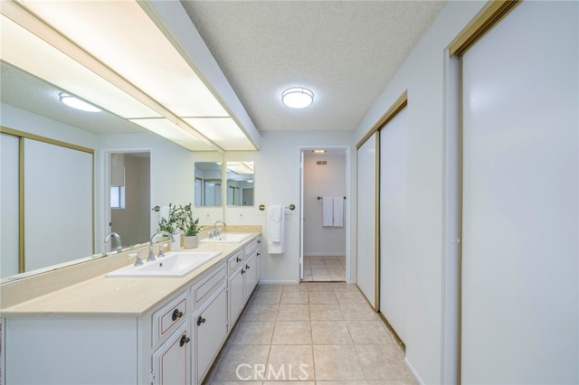 Primary bathroom with double vanity, 3 sets of closets and separate shower and water closet area