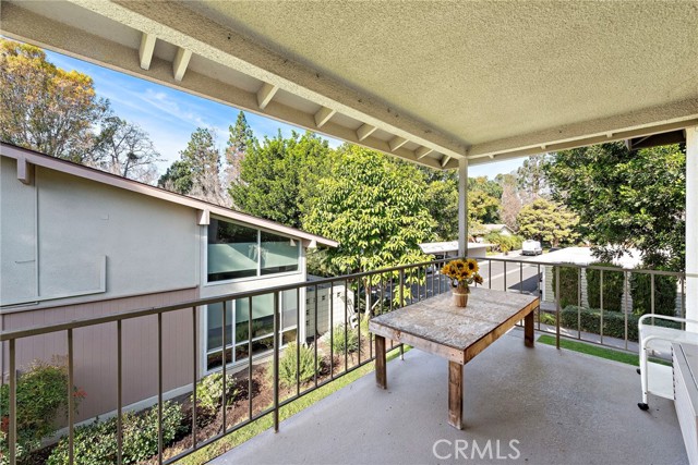 Another view of the covered balcony with neighborhood and tree views.