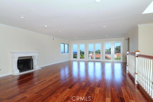 Spacious living room features fireplace, recessed lighting and gorgeous wood floors.