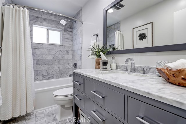 Fully remodeled upstairs bathroom with new vanity, quartz countertop, and modern accents.