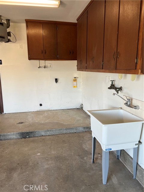 Laundry area with mop sink in garage