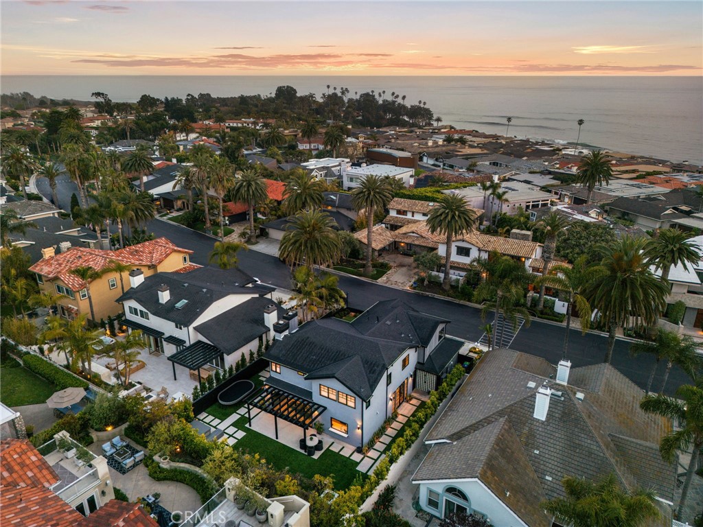 A full renovation, down to the studs, with an impressive new style and exceptional luxury distinguishes this partial ocean-view home in the exclusive guard-gated Breakers community on the Shores side in San Clemente. Providing a tranquil setting and neighborhood private beach access this home wrapped in distinctive full wood grain siding is in proximity to open nature and some of California’s best beaches, including Trestles, which gives this home a unique, coastal retreat feel. Interiors spaces offer 2,950 +/- s.f., of elegant comfort and bold design with 4 bedrooms, and 5 bathrooms. Upon entry you are greeted with an airy entry hall with exceptionally tall ceilings, creating a stunning first impression. Concrete tile-like floors shine, and a formal living living space exudes the California beach lifestyle with metal and glass bi-folding doors that open to the front courtyard and dining room feature statement lighting. The family room is a relaxed open concept space, where light and air filter through bi-folding glass doors that open to the backyard, offers a fireplace swathed in black brick, with bar seating connecting to an oversized island with quartz counters. Custom cabinets and floating shelves in the kitchen, with a seamless panel refrigerator and a window that opens to the backyard are amenities perfect for upscale entertaining. All the bedrooms boast completely remodeled en-suite bathrooms, which showcase stunning custom tile-work, are quiet retreats with clean, simple details. Best of all is the primary bedroom with an enviable en-suite that offers dual vanities, a freestanding soaking tub, and a separate custom shower. Exterior spaces are fantastic focal points, with new front and rear hardscape, a spa with soothing water features, and a custom fire pit that creates a cozy place for year-round stargazing. The renovation was completed in January 2023 and includes new windows and doors, a new roof, new AC units, tankless water heater, custom railing and stairs, new hardscape and turf front and rear for low maintenance, a built in BBQ, whole house water filtration system and reverse osmosis, all new surfaces throughout, outdoor shower, and a 3-car garage with plentiful built-in cabinetry and new garage doors, The Breakers community offers residents amenities such as a pool, spa, pickleball court, private park, and is conveniently located near top-rated schools, world class surfing, restaurants and shopping on Del Mar Street.