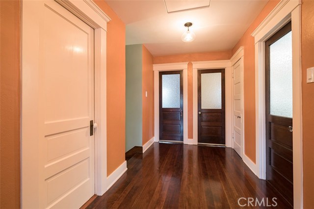 Upstairs hallway exhibits the classic bedrooms glass doorways with period lighting.