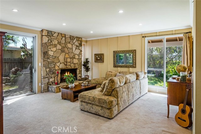 A cozy fireplace lined in Palos Verdes Stone in the step down living room.