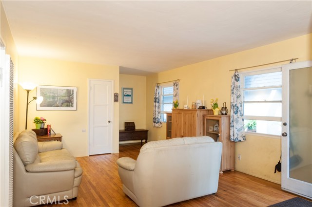 Same room taken from the kitchen doorway. Excellent space for a desk in corner. White door is more storage.