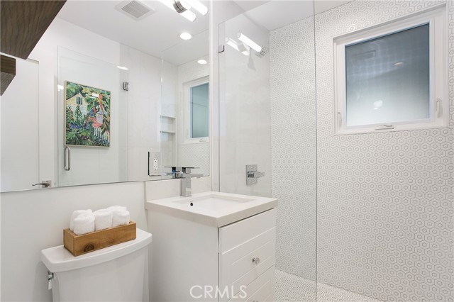 Updated bathroom with floating vanity, glass enclosed shower.
