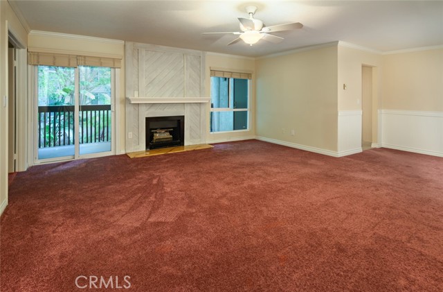 Living room with cozy fireplace and direct access to extra large balcony with lush garden view.