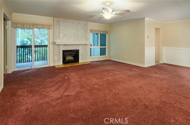 Living room with cozy fireplace and direct access to extra large balcony with lush garden view.