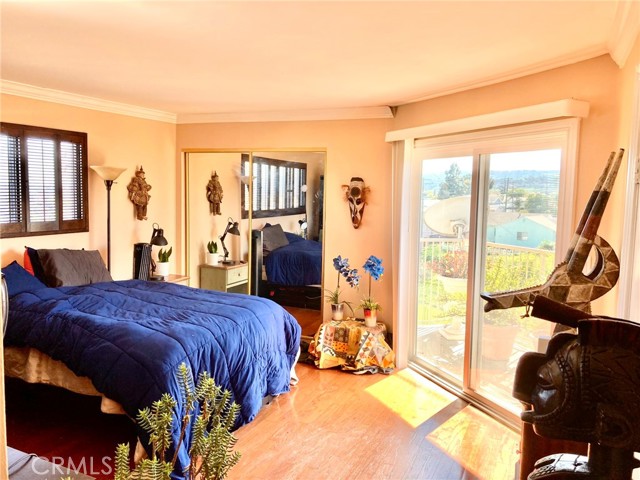 Elegant master bedroom with two closets, a walkout balcony, and views of the city and the ocean side.
