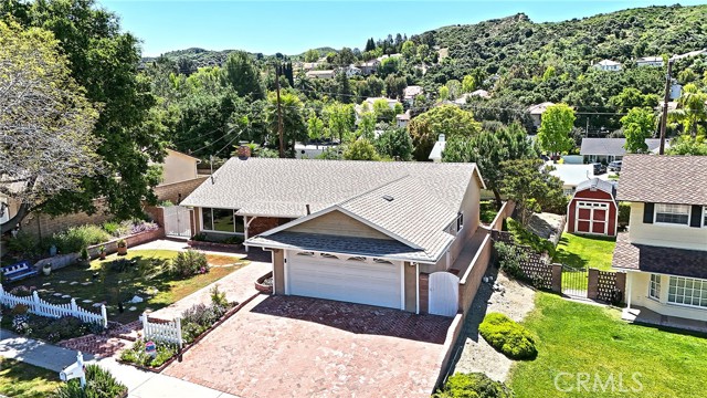 Welcome to 23508 Adamsboro Drive, Newhall—a delightful single-story residence in a coveted neighborhood. This charming abode boasts an inviting open-concept layout complemented by a generously sized bonus/living room. Adorned with upgraded dual-paned windows, the family room offers picturesque views and a cozy brick fireplace for warmth and ambiance. Step into the dining area, graced with gleaming upgraded vinyl floors. The spacious living room/den effortlessly flows into the expansive private yard, perfect for outdoor gatherings and relaxation. 
The well-appointed kitchen has ample cabinet and counter space, including a sizable pantry, catering to all culinary needs. Retreat to the master suite, which affords serene views of the backyard, and indulge in the updated master bathroom, which boasts a luxurious walk-in tile shower. Two additional bedrooms of comfortable dimensions share a well-appointed second bathroom. Outside, the private rear yard beckons with its ample space for entertaining, complemented by a covered patio, storage shed, and expansive side yards. Additional features include an indoor laundry area, upgraded main electrical panel, solar panels, storage battery (no worries when the power goes off),  and a convenient 2-car garage.
With NO HOA fees, NO Mello Roos, and convenient freeway access, this home presents an irresistible opportunity. Don't miss the chance to make this gem your own—schedule a viewing today and come imagine the possibilities at this charming home.