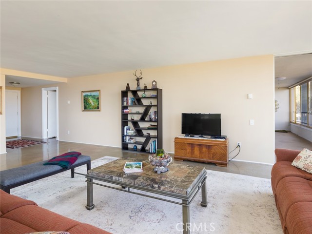 Another view of the living room. Entry into hallway leading to bedrooms is visible on the left. Balcony that is also accessed from both bedrooms is visible on the right.