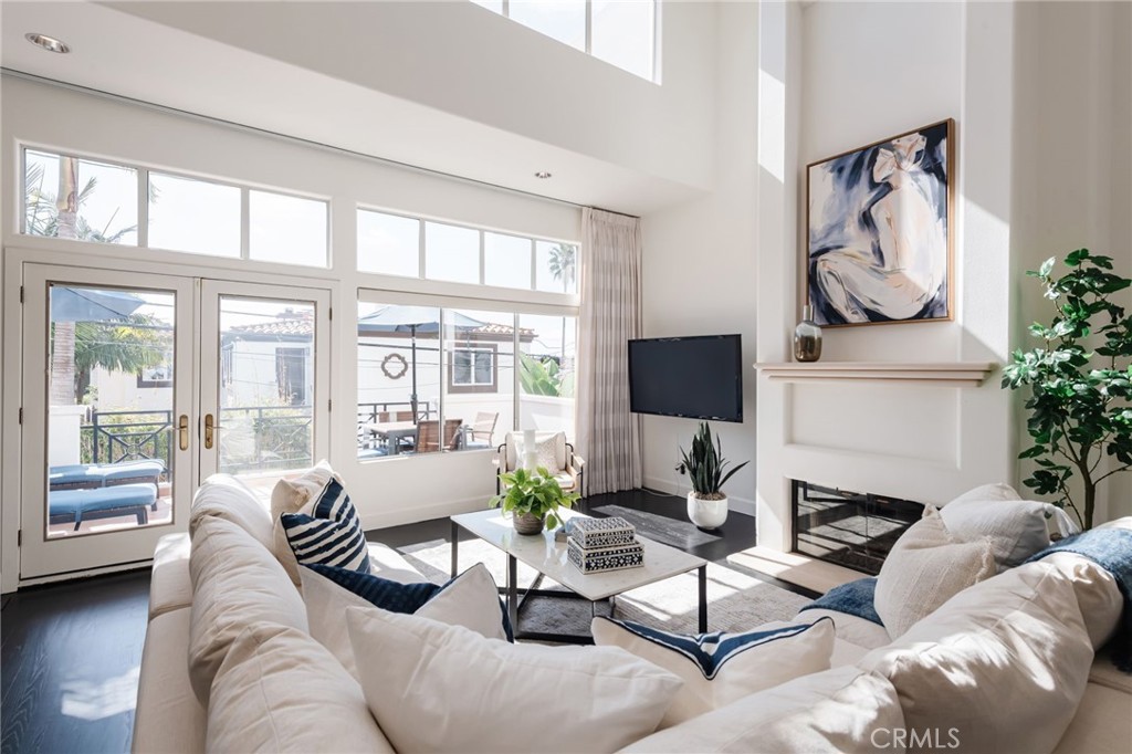 Sheer elegance by the beach!  Downtown Manhattan Beach location features this stunning end unit, ocean view townhome with really impressive outdoor spaces on 2 levels.  This well appointed home's dramatic feel is highlighted with dark wood floors, white walls, floor to ceiling windows, sweeping motorized drapes and double level ceiling height.  The entry level features the rich master suite (with a walk-in closet, marble and stone bathroom, a large private patio perfect for morning yoga stretches or riding your Pelaton) and the beautiful second bedroom with en-suite bathroom.   Upstairs, the family room, powder room, dining area, chef's kitchen and ocean view outdoor living room (complete with outdoor speakers) derive ocean breezes and abundant light through a wall of windows.  One more spiral stairwell up reveals the Palos Verdes and ocean view open loft/office/den space.  This unit has a two car garage plus an extra spot.  It is also positioned on the 11th Place side of the lot providing privacy and a quiet atmosphere for living the best beach life.  Walk to dinners in town, the grocery store, the greenbelt or head straight down to the pier and catch a famous Manhattan Beach sunset.