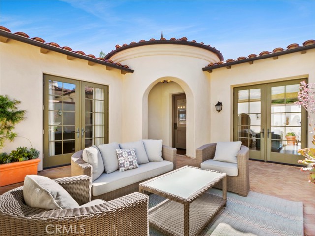 Patio courtyard can be accessed from the den (left), the front door (in the archway ) and the kitchen (right )