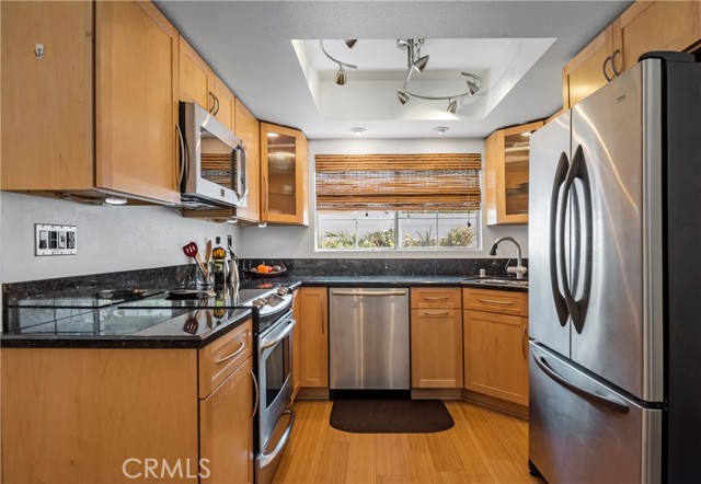 Remodeled kitchen with granite counters, glass cabinet doors & stainless appliances