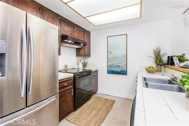 kitchen has electric stove, dishwasher, refrigerator and bar/counter
