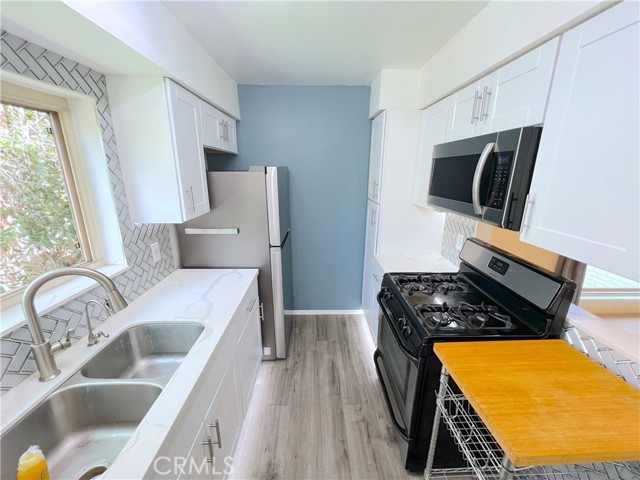 Kitchen showing newer appliances, microwave.  Lighting under floor cabinets.