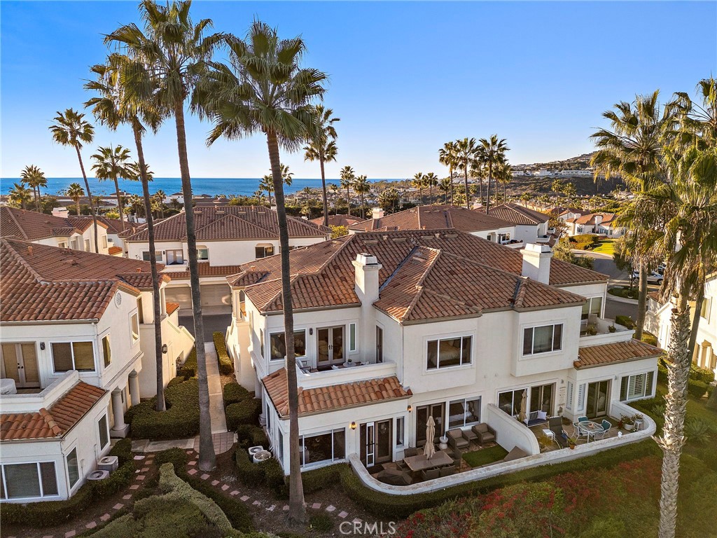 Offering fairway views from its prime location on the 16th hole of the Monarch Beach Golf Course, this luxurious, fully remodeled, townhome showcases an extensive high-end remodel with countless upgrades and premium finishes. A coveted address behind the gates of the exclusive Tennis Villas neighborhood complements the residence, which also presents a peek at the ocean, two patios, and a spacious single-level floorplan of approximately 1,357 square feet with no one above. Reimagined to create a more open, free-flowing design, the bright and welcoming home is full of natural light and offers impressive entertaining with a living room that hosts a patio and top-spec surround sound with flush-mount wall and ceiling speakers, and a dining room with custom stone accent wall. With two walls removed as part of the remodel, the living and dining rooms flow freely to a custom kitchen with patio, quartz countertops illuminated by under-cabinet lighting, full tile backsplash, a peninsula with waterfall edge and bar seating, custom solid-wood white Shaker cabinetry with soft-close doors and drawers, and preferred stainless steel JennAir appliances including a six-burner range, drawer microwave and built-in refrigerator. Enjoy Provenza engineered hardwood flooring throughout, high ceilings, recessed LED lighting, contemporary light fixtures, smooth-finished walls, dual-pane low-e Milgard windows and French doors with upgraded casings, motorized Lutron shades controlled by an app, remote and switch, a smart Honeywell Wi-Fi thermostat, Ring doorbell and interior laundry. Two bedrooms and two baths include a view-enhanced primary suite with patio, ensuite bath and generous walk-in closet. The secondary bedroom is ensuite as well, with both baths showcasing quartz countertops, top-tier plumbing fixtures, and custom glass shower enclosures. Attention is also lavished in the two-car garage, which boasts professionally installed epoxy flooring, an EV charger, plus cabinetry and a workbench with LED lighting. Tennis Villas reveals a beautiful resort setting with a private pool and soothing spa. All residences were upgraded with PEX piping by the HOA. Adjacent to the Tennis Club at Monarch Beach and directly across the street from the opulent Waldorf Astoria Monarch Beach, the intimate enclave is moments from Dana Point Harbor, Ocean Ranch Village, Monarch Beach Plaza, Salt Creek Beach, The Ritz-Carlton, and is just a short stroll or bike ride to the actual beach!