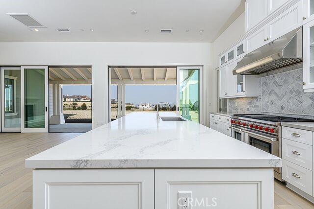 Kitchen light and bright, with stacked sliding doors open to the covered back patio.