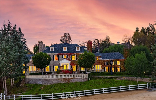 Every element of a true estate property, presented on nearly six acres in the private, exclusive Los Ranchos Estates. Grand and timeless, the main residence, guest house, barn and stables are pristinely articulated, reminiscent of European-Georgian style structures – bearing the hallmarks of exceptional traditional architecture. Enveloped by panoramic mountain, hillside, pasture, and woodland vistas, the completely gated equestrian compound is thoughtfully set amid mature, manicured grounds - enjoying verdant views from every vantage point. A gracious experience upon entry, an expansive tree-lined drive and stone-paved motor court is a mere introduction to the stately primary residence. Impressive in scale and construction, the home encompasses myriad formal and informal living spaces, seven bedrooms, nine baths, an art studio, dance studio, fitness room, media room, an office, service quarters, lounge, library, a subterranean wine room, and a kitchen equipped for entertaining of any style. Generously adorned with the finest finishes, no expense was spared when fashioning appointments – abundant use of exotic hardwoods and stones; coffered wood and medallion metal ceilings; designer fittings, fixtures, hardware, lighting installations, wall and window coverings; professional-grade appliances; custom millwork; six European-style fireplaces; and artisan-crafted architectural details and environmental art pieces create a perfect harmony between luxury and modern domesticity. The serene grounds are splendidly balanced with features to afford relaxation and recreation – tranquil terraces, a sparkling pool and spa, pool pavilion, and outdoor fireplace and living area exist in idyllic seclusion; and the adjacent paddocks, riding arena, and stables with accommodation for six horses, a tack room, office and living quarters are befitting for even the most discerning equestrian. Spectacular detail was bestowed in composing this parcel beyond compare – creating luxuriant, yet comfortable environments across the acreage.