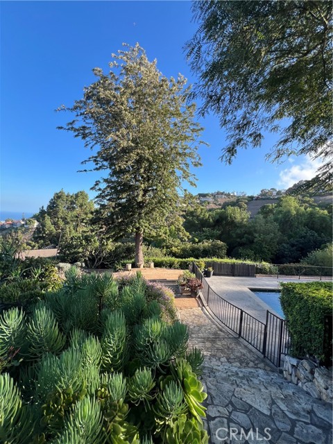 Gentle stairway down to Pool Level completely fenced and features a waterfall.On the opposite side is a large grassy lawn. There is a Garden Road to the pool and another branch rood down to future Barn.