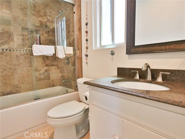 The secondary bedroom attached bath with upgraded bath, sink and mirror.