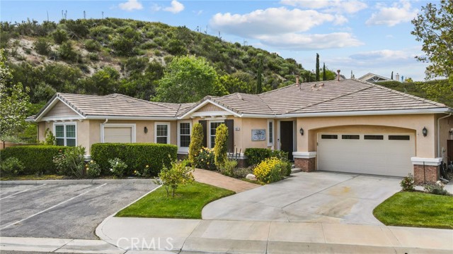 Welcome to the LARGEST SINGLE-STORY Friendly Valley home on a huge 11,284 SF lot. This home is nestled on a tranquil cul-de-sac in an exclusive, guard-gated 55+ country club community with a 9-hole Executive Par-3 golf course. This professionally expanded home features 3 bedrooms/3 full baths, plus a bonus room & den. Just minutes from the 14 Fwy, a short distance to shopping, restaurants, and amenities galore! This immaculate and updated home is truly move-in ready, featuring gorgeous luxury tile flooring and warm wood flooring throughout the sweeping single-story floor plan, gorgeous light fixtures, and recessed lighting. The beautiful foyer makes quite a statement as it opens to the expansive living and dining rooms with a sit-up counter seating area and an upgraded kitchen! The entry also leads you to one wing of the home with 2 spacious bedrooms, each with its own bathroom. The first has a shower/tub combo, and the other has direct slider door access to the private and beautifully manicured backyard! The second of three upgraded baths boasts a full-size shower with wheelchair access, a vanity, & plenty of natural light! The stunningly renovated kitchen features granite countertops, an instant hot faucet, shaker-style soft close cabinetry, stainless steel appliances, room for a small breakfast table to enjoy morning tea, a slider with access to a large patio perfect for outdoor entertaining! The living & dining rooms have a gorgeous fireplace, large windows, and an extra door to outdoor living areas! Through the family room, the bonus room could be perfect for a library or lounge with high ceilings, recessed lighting, and a ceiling fan. In addition to the 2 car-attached garages with an extra storage area, there is also a 3rd insulated space complete with recessed lighting, and an additional storage area, perfect for your golf cart, meditation or art studio, or anything you choose! This lovely addition takes you outside to the lushly manicured, huge backyard with beautiful hillside views! The laundry room is full-sized, complete with sink and storage cabinets, which leads to the light and bright primary bedroom, an ensuite bath with dual sinks, and a tiled walk-in shower! The community boasts many amenities, such as a recently remodeled, swimming pool & clubhouse, 18 hole pitch & putt course, tournament-style lawn bowling field, basketball court, a woodwork shop, ceramic shop, RV parking facilities, & so much more! This special home will not last long!