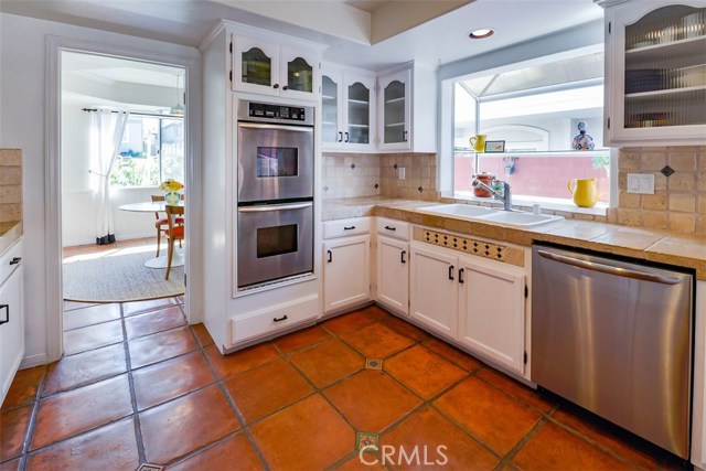 Another shot of the kitchen showing the double oven, dishwasher, and garden window.