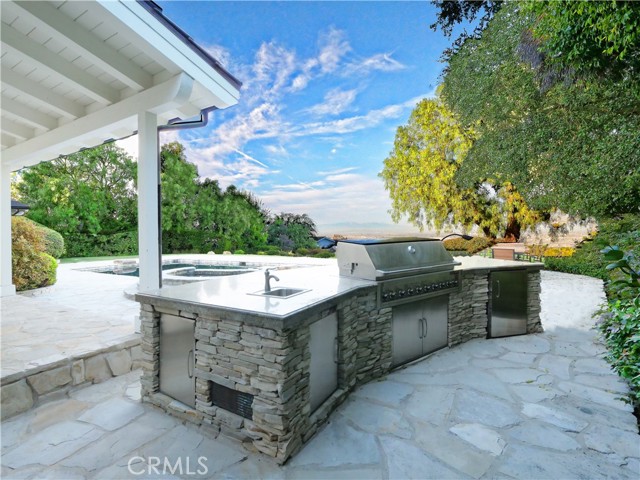 Outdoor kitchen with built in BBQ, refrigerator and sink