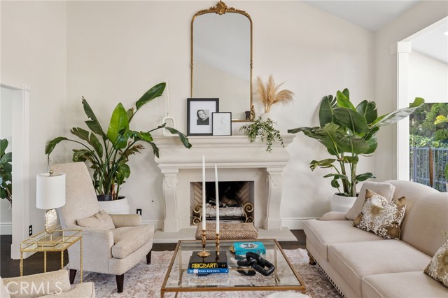 The Formal Living Room with soaring vaulted ceilings, a romantic custom fireplace, and wide plank French oak floors.