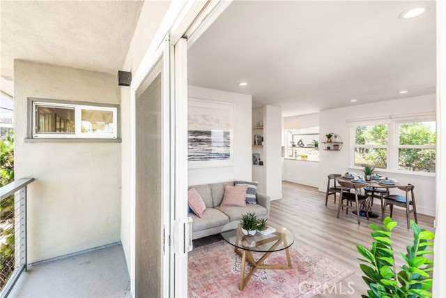 Indoor/outdoor with living room offering sliding doors to the balcony
