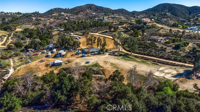 **Legacy owned** (long term) property, not on the open market for 40 years. The lot, which is over 10 acres, has three mobile homes and various other small structures including a barn. The owners believe one of the primary and strongest features is the amount of usable flat acres at the site. The entire frontage of the lot facing Oak Circle drive is a gentle sloping section. Larger flat sections where each mobile home currently sit are key also. The city of Wildomar will be improving/developing the corner of Bundy Canyon Rd/Oak Creek Rd with a traffic light and four corner improvement project, in the next several years per the building department. Bundy Canyon Rd is currently in the process of a city approved road project. This property offers a lot of potential for future development and improvement. Some water views of Lake Elsinore from the middle and top sections of the lot.