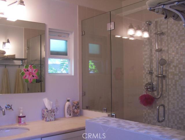One of Two Bathrooms. Remodeled in 2009 with Double Shower Heads (One Rain Shower). Grohe Fixtures, Travertine Slab Counter Top. Bathroom attached to second bedroom was a Total Remodel with New Mosiac Tiles, New Tub and Fixtures.