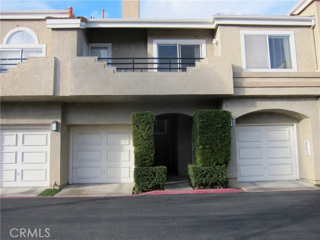 Unit with balcony above garages. Entry to the front door and garage in on the left side.