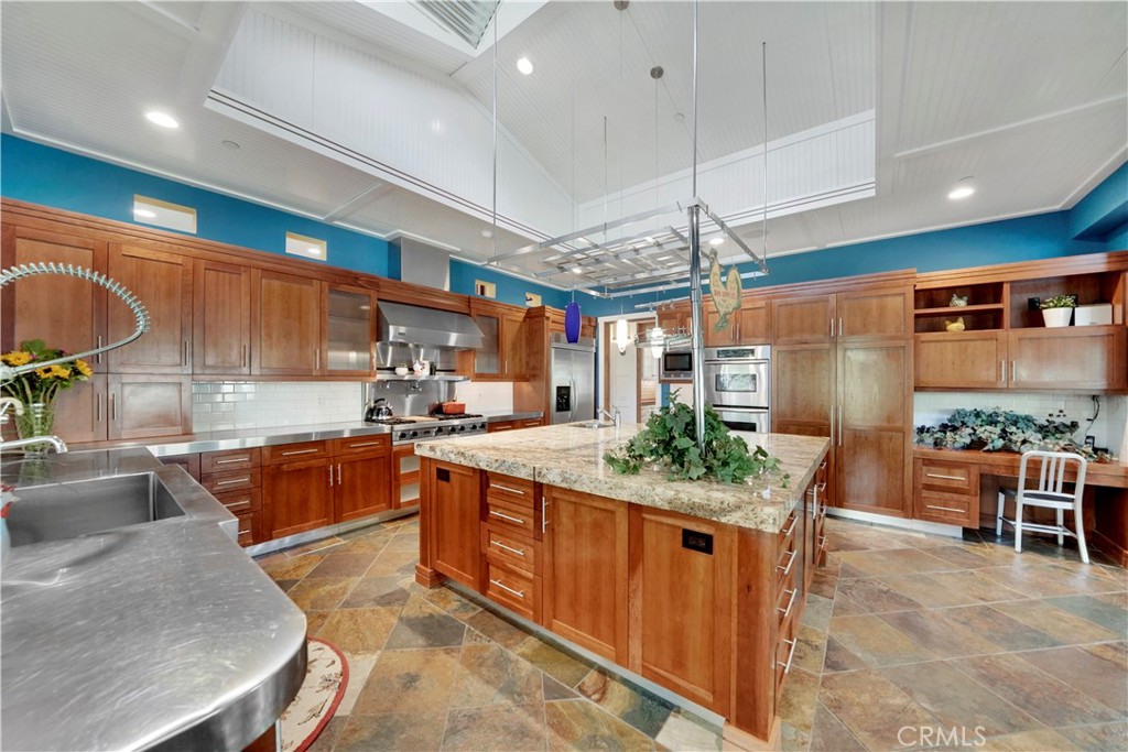Custom cabinetry, stone floors, built in desk and metal counters