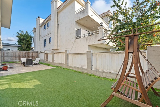 Very large and private bricked patio with lush grass and privacy fencing