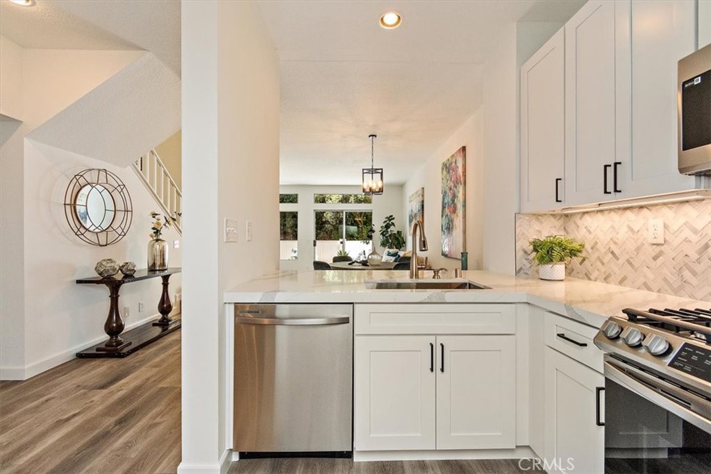 Remodeled kitchen features all new white shaker cabinet with soft close doors and drawers, matte black pulls, Calacatta Leon quartz countertop & breakfast bar, chevron glass & tile back splash, under cabinet lighting, all new stainless appliance, stainless sink & brush nickel faucet.