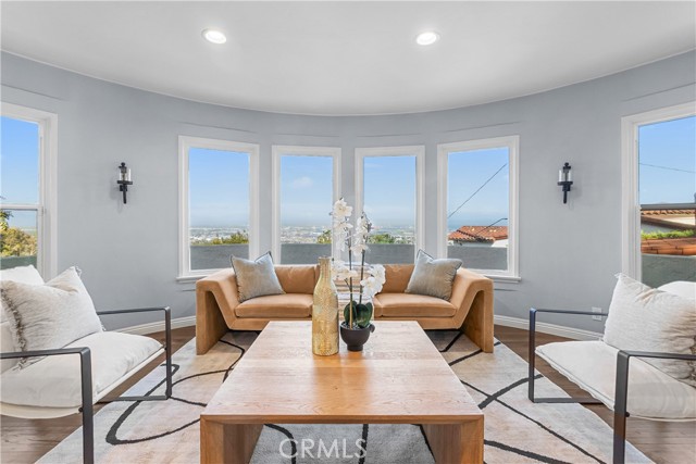 The living room is appointed with rich hardwood floors, an elegant stone fireplace, and subtle designer tones.