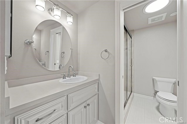 The master bathroom offers dual facing vanities with quartz countertops, new cabinetry, designer mirrors and light fixtures.
