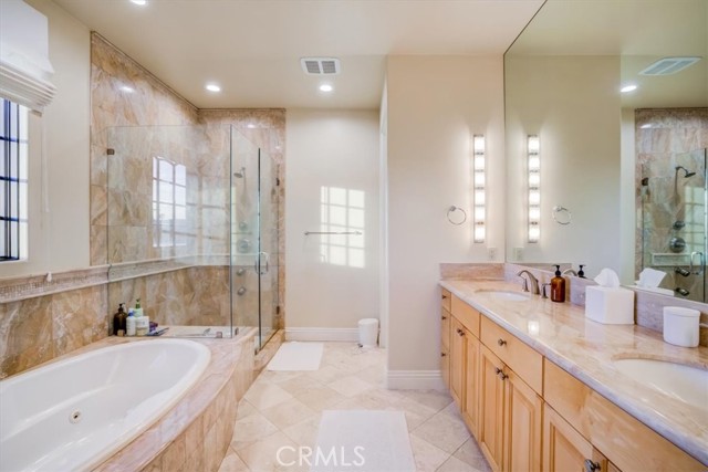 Primary Suite bathroom with double sink, soaking spa tub and walk in shower.