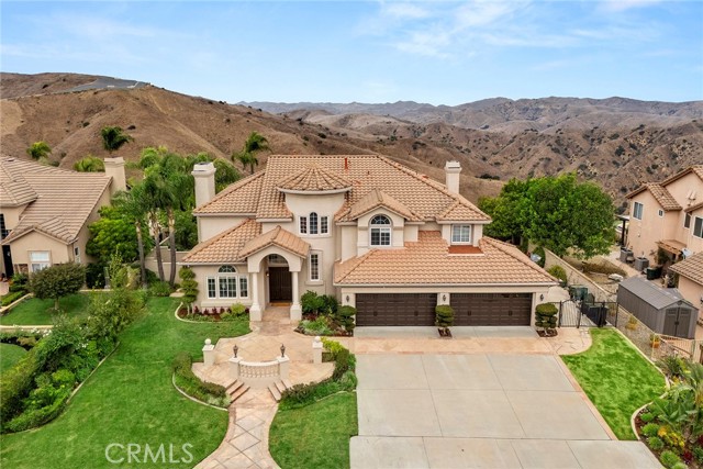 Located in the prestigious Vista Bel Aire estates, this fine home has one of the best canyon views on a large lot.  This is an estate home with 5 bedrooms and an office and 5 bathrooms. Entering into the formal entry immediately gives you that spacious feel.  Two staircases, the curved one in the foyer and then the back staircase for easy access from the back bedrooms. On the main floor is the open office in the front of the house, then a living room with a fireplace that leads to the dining room with views to the mountains.  By the way, the views are even more spectacular during the winter with snow on the mountains. Come on into the kitchen that gives you that very open feel with a breakfast nook and the expansive family room. The kitchen has a built-in Electrolux refrigerator, a 5-burner cooktop, microwave, double oven and a prep sink in the center island. You can sit at the front island bar counter and watch the activities going on in the kitchen or sit at the breakfast nook for a meal or enjoy the comfortable family room with a fire going or grab a book from the built-in cabinetry and enjoy your favorite show on TV, or just relax staring at the view of the pool or the mountains.  The main floor also has a bedroom with ensuite bath.  Then we go upstairs from the curved staircase to the landing that lead to the left into the primary suite and bath.  Such great space!  It truly is a suite with seating that looks out at the back view. There is even plenty of room for a workout area at one end of the room. Step inside the primary bath with its jetted tub, double sinks, two toilet rooms, and a shower that is huge and with dual shower heads and two walk-in closets.  This is resort living and you can soak in the tub and take in the view. Finally, there are three additional bedrooms and a loft area on this floor.  Two bedrooms are attached with a shared bathroom and the third has its own bath. High ceilings throughout this home compliment the spacious feeling. We have already bragged about the views so now we can go outside and see them in person. With a big yard and a big pool and spa, it is paradise!  Do you like golf, then bring your putter for the artificial grass putting green.  Great for parties with a BBQ island for entertaining and a grass area for the pets. There is even a potential for RV parking on one side.  In addition, you have a four-car garage and plenty of driveway for your guests. This one is worth seeing.