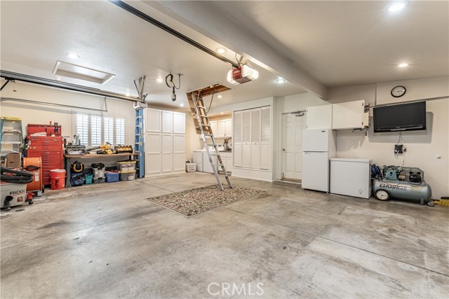 Three car garage with tv, 
and pull door storage