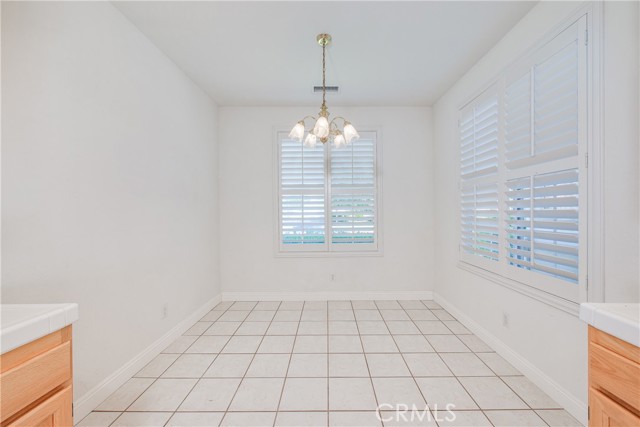 Large dinette with tile floors and plantation shutters. Golf course and lake views from the front dinette window.