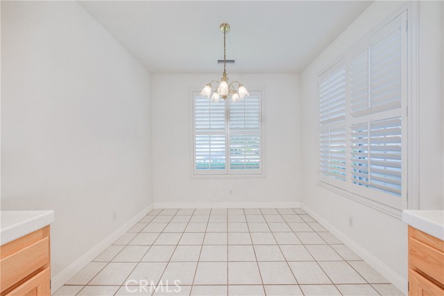 Large dinette with tile floors and plantation shutters. Golf course and lake views from the front dinette window.