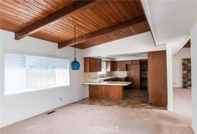 Beam ceilings in dining room, kitchen and living room. This picture was taken standing in the entry looking through the dining room into the kitchen. There is direct access into the home from the garage through the kitchen (back of picture).