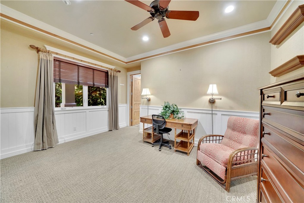 main floor bedroom with ceiling fan and shelving