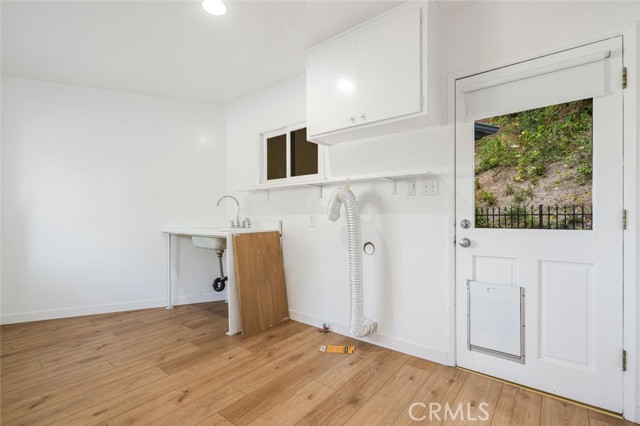 Large laundry room with sink and storage