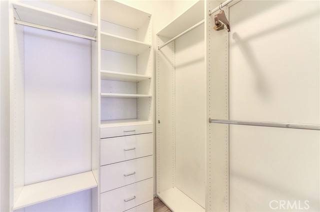 Walk in closet with built in drawers.