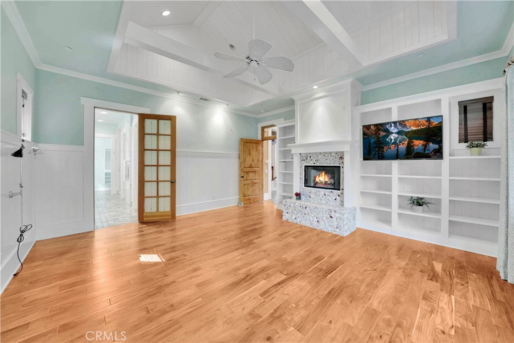 master bedroom with fireplace and custom ceiling and built in shelves