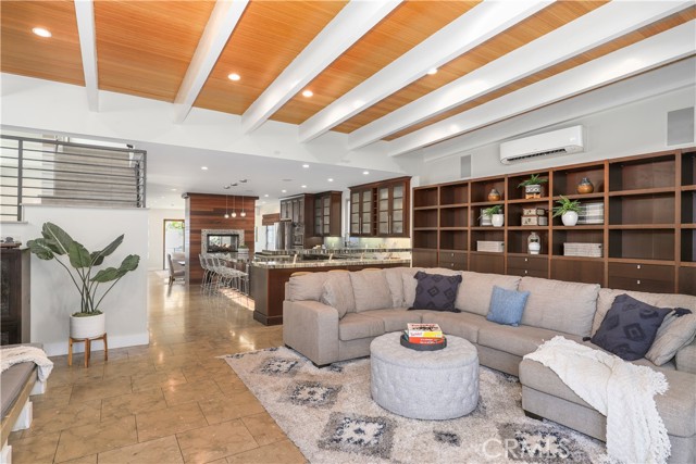 Great shot showcasing a built in wall of shelving, the kitchen and beautiful craftsmanship on the ceiling.